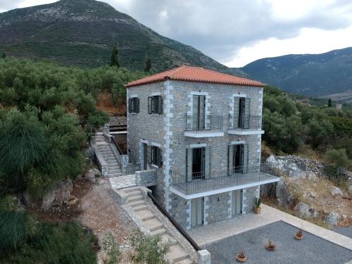 an external view of a building with mountains in the background at Lithorama Residence Mani - Second Floor in Koúmani