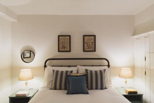 ein Schlafzimmer mit einem weißen Bett mit zwei Lampen in der Unterkunft Buckingham Mews Pebble Cottage 3 in Broadstairs