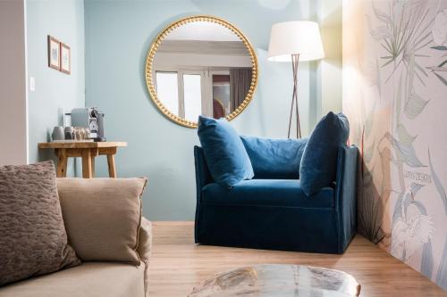 a blue chair in a living room with a mirror at Strandhotel Schmerikon in Schmerikon