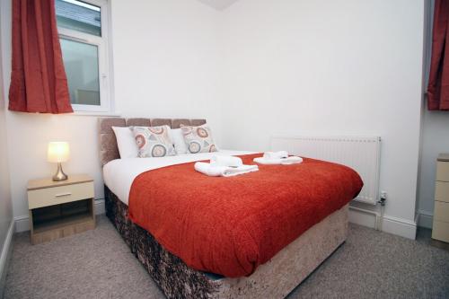 um quarto com uma cama com duas toalhas em Camelot House by Tŷ SA em Newport