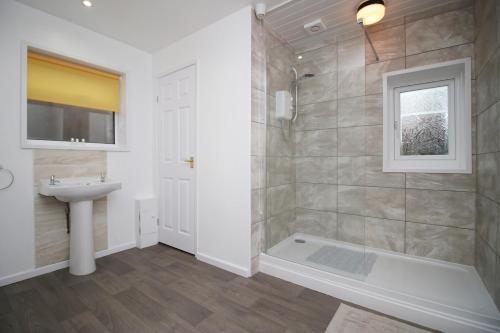 a bathroom with a shower and a sink at Camelot House by Tŷ SA in Newport