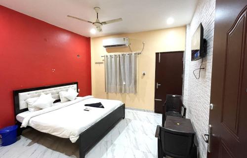 a bedroom with a bed and a red wall at Four Seasons Paying Guest House in Varanasi