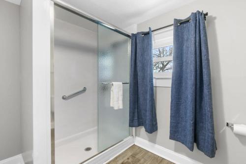 a bathroom with a shower with blue shower curtain at 1 Mile to Birmingham CrossPlex & Near Legion Field in Birmingham