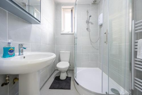 a bathroom with a sink and a toilet and a shower at Modern 1 bedroom - Church View 4 by Tŷ SA in Newport