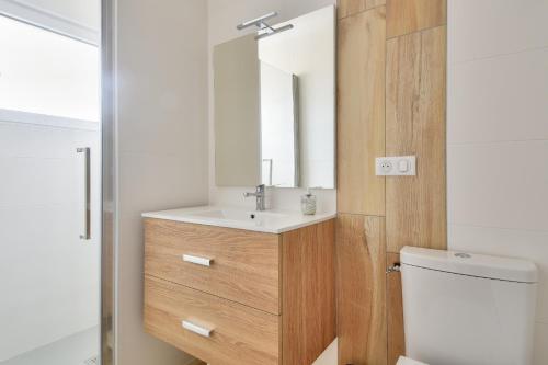 une salle de bain avec un lavabo et un miroir dans l'établissement 350 m de la plage - Appart avec grande terrasse, à Sion-sur-lʼOcéan