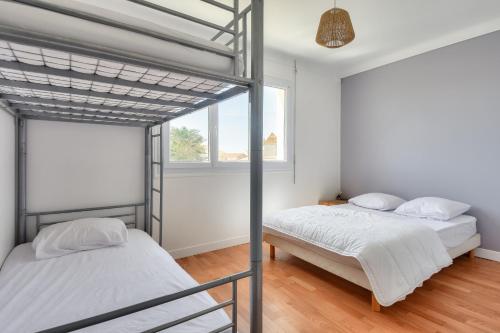 deux lits superposés dans une chambre avec fenêtre dans l'établissement 350 m de la plage - Appart avec grande terrasse, à Sion-sur-lʼOcéan