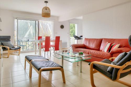 un salon avec un canapé rouge et une table dans l'établissement Proche plages et commerces, appartement pour 4, à Fouesnant