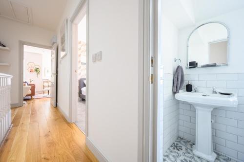 a white bathroom with a sink and a mirror at Central Location - Riverside Gardens #2 by Tŷ SA in Cardiff