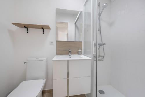 une salle de bain blanche avec des toilettes et un lavabo dans l'établissement Maison récente à Pornic 500m de la plage pour 5, à Pornic