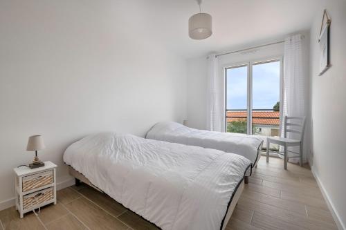 deux lits dans une chambre avec une fenêtre dans l'établissement Maison récente à Pornic 500m de la plage pour 5, à Pornic