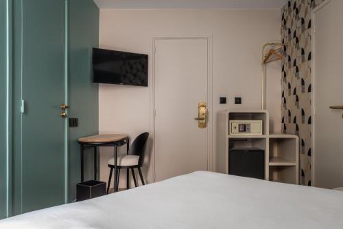 Cette chambre comprend un lit, une table et un tabouret. dans l'établissement Arc Elysées, à Paris