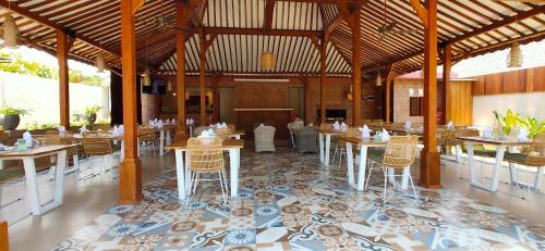 a restaurant with tables and chairs in a room at Taman Amertha Villas by Maha Bali in Seminyak