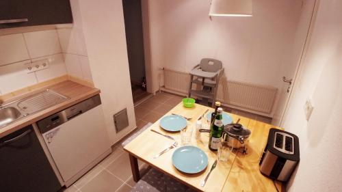 een kleine keuken met een houten tafel met blauwe platen erop bij Fehmarn Ostseeferien Feerjenkate Fehmarn 218 in Fehmarn