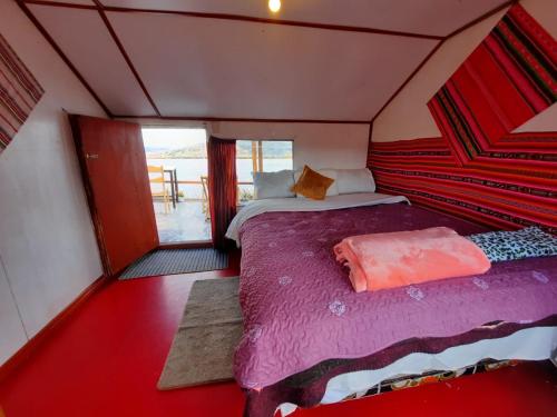ein Schlafzimmer mit einem Bett in einem kleinen Zimmer in der Unterkunft Uros Titicaca UMA lodge in Puno