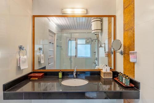 西姆拉的住宿－Alaya Stays Meridian Oak 5BHK Villa in Shimla，一间带水槽和大镜子的浴室
