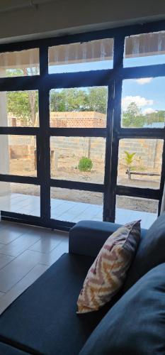a couch in a living room with a large window at Aima Villas in Chanamo