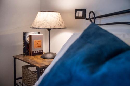 a bedside table with a lamp and a book at La Volta in Trevi