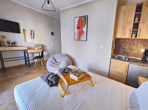 a room with a bed and a table and a kitchen at StayInn Luxury Apartments in Nea Kalikratia