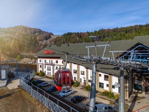 a red train on a lift in front of a building at Hotel Jaworzyna Krynicka in Krynica Zdrój