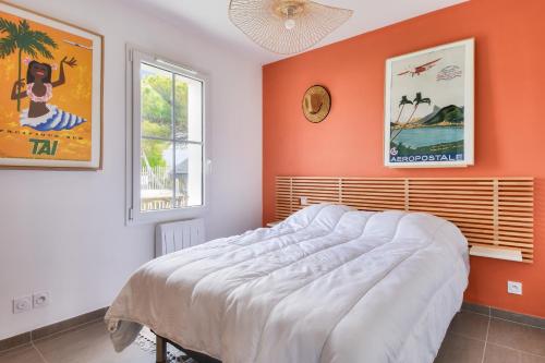 - une chambre avec un mur orange et un lit dans l'établissement Maison pour 4 - jardin - 600m de la plage, à Barbâtre