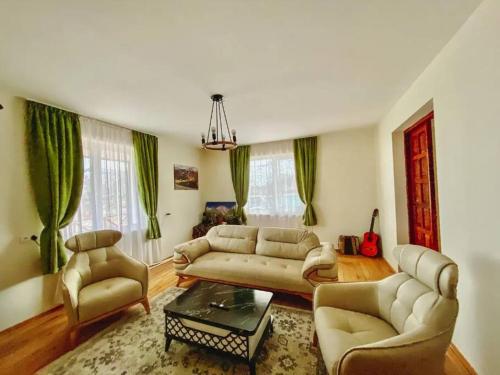 a living room with a couch and chairs and a table at Gudauri Deka House in Gudauri