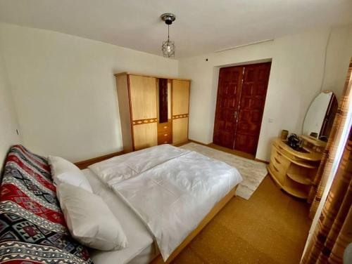 a bedroom with a white bed and a mirror at Gudauri Deka House in Gudauri