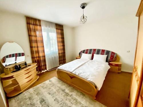 a bedroom with a bed with a mirror and a rug at Gudauri Deka House in Gudauri