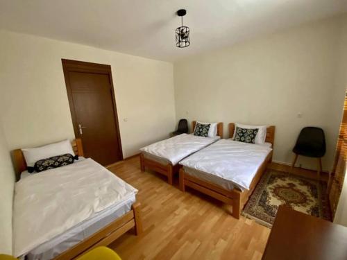 a bedroom with two beds and a table at Gudauri Deka House in Gudauri