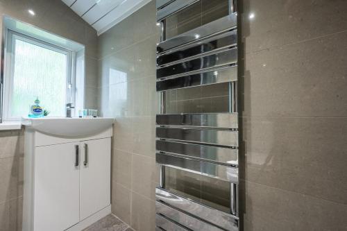 a bathroom with a shower with a sink and a sink at Chapel Lodge by Tŷ SA in Newport