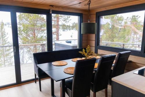 una sala da pranzo con tavolo, sedie e finestre di Jutulhytta a Litle Løkken