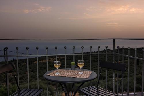 two glasses of wine sitting on a table on a balcony at Lithorama Residence Mani - Second Floor in Koúmani