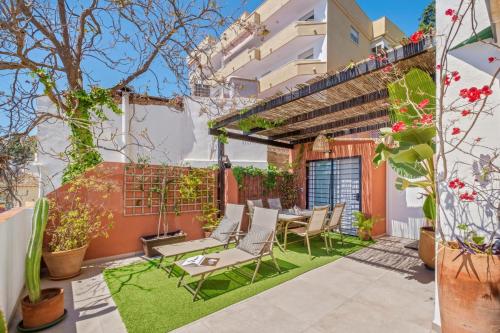 a patio with chairs and a table in a building at Mar de fondo en Pedregalejo in Málaga