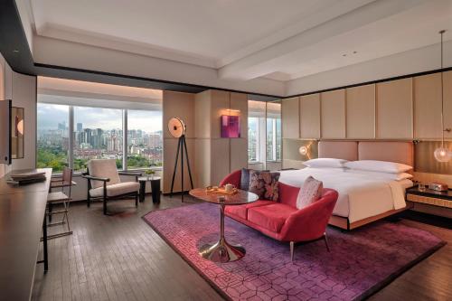 ein Hotelzimmer mit einem Bett und einem Wohnzimmer in der Unterkunft Hyatt Centric Zhongshan Park Shanghai in Shanghai