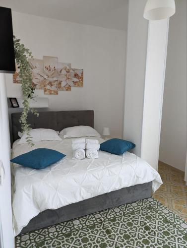 ein Schlafzimmer mit einem großen Bett mit blauen Kissen in der Unterkunft Piccolo appartamento con grande terrazzo panoramico in Maiori