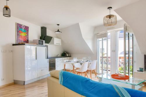 un salon avec un canapé bleu et une table dans l'établissement Proche plages et commerces, appartement pour 4, à Fouesnant
