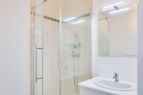 une salle de bain avec douche et lavabo dans l'établissement Proche plages et commerces, appartement pour 4, à Fouesnant