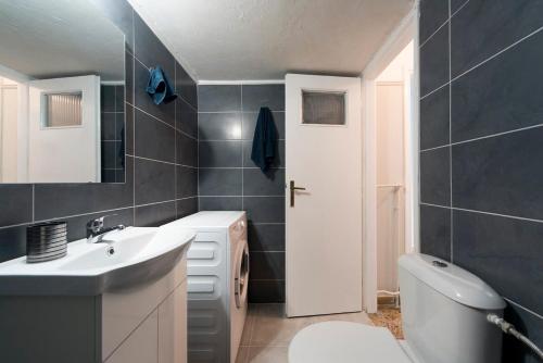 uma casa de banho com um lavatório branco e um WC. em Central apartment 3' to Metaksourgio metro station em Atenas