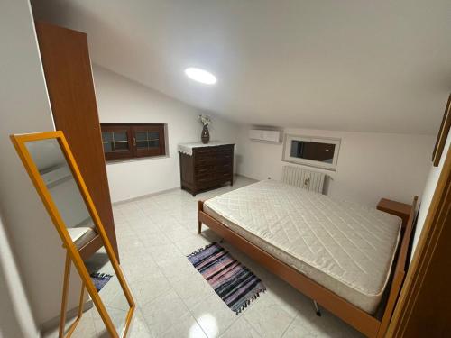 ein Schlafzimmer mit einem Bett und einer Kommode in der Unterkunft Mansarda a Foiano in Foiano di Val Fortore
