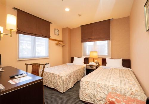 Postel nebo postele na pokoji v ubytování Kiryu Ace Hotel