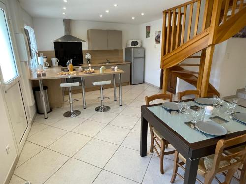 une cuisine avec une table à manger et une cuisine avec un escalier dans l'établissement La tour, à Saint-Thomé