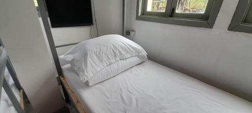 a white pillow sitting on a bed in a room at MK Hostel in Luang Prabang