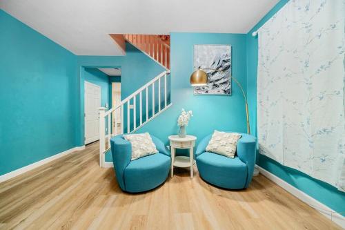 Habitación azul con 2 sillas y escalera en 4 bd house with backyard near Disneyland, en Placentia