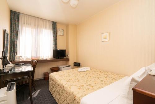 Postel nebo postele na pokoji v ubytování Kiryu Ace Hotel