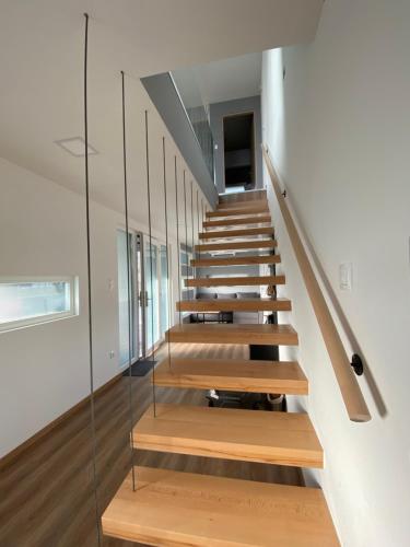 a staircase in a house with a glass wall at Swan Apartman in Sándorfalva