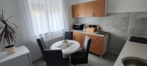 eine kleine Küche mit einem Tisch, einem Tisch und Stühlen in der Unterkunft Apartman Stanković in Odžaci