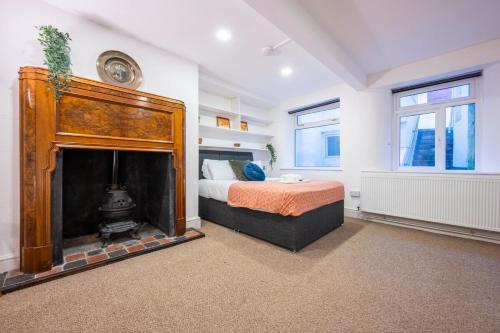 a bedroom with a bed and a fireplace at Palmyra Square by Tŷ SA in Newport