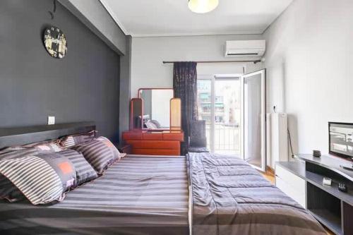 ein Schlafzimmer mit einem großen Bett und einem großen Fenster in der Unterkunft Topfloor central apt with urban views,3' to metro in Athen