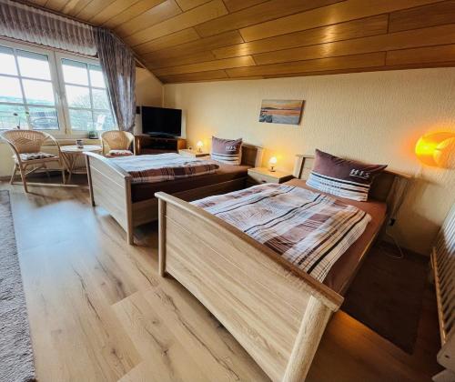 アンダーナッハにあるFeWo Ferberのベッド2台、デスクが備わる広い客室です。