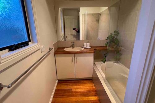 een badkamer met een wastafel, een bad en een spiegel bij Las Elenas in Magpie