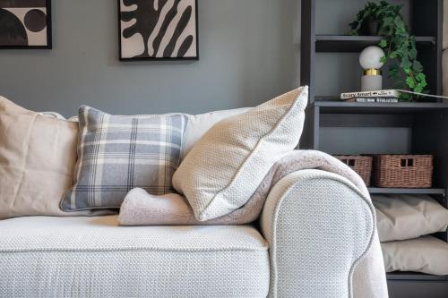 una sala de estar con un sofá blanco con almohadas en Close to Warwick University - Clover Way by Tŷ SA, en Canley